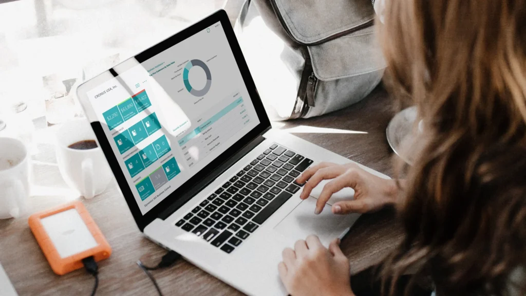 Foto einer Frau über die Schulter, die mit Microsoft 365 Business Central arbeitet, 